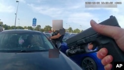 This image from video shows an officer pointing his gun at Ta’Kiya Young moments before shooting her through the windshield, in Blendon Township, Ohio, on Aug. 24. Police pixelated the photo. (Blendon Township police via AP)