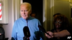 US President Joe Biden talks to reporters aboard Air Force One during a refueling stop at Ramstein Air Base in Germany, Oct. 18, 2023, as he travels back from Israel to Washington. 