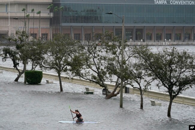 Zeke Pierce rides his paddle board down the middle of a flooded Bayshore Blvd in downtown in Tampa, Fla., Wednesday, Aug. 30, 2023. Hurricane Idalia steamed toward Florida’s Big Bend region Wednesday morning, threatening deadly storm surges and destructive winds in an area not accustomed to such pummeling. (AP Photo/Chris O'Meara)