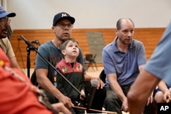 Nation Wright Sr. and his son Niigaanii sing on the drum during an open drum and dance night at Minneapolis American Indian Center, July 10, 2024, in Minneapolis, Minnesota.