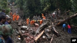 FILE - Rescuers search the debris for survivors after a landslide following heavy rainfall in Shimla, India, Aug. 17, 2023.