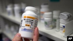 FILE - A pharmacist holds a bottle of the antibiotic doxycycline hyclate in Sacramento, California, July 8, 2016. 