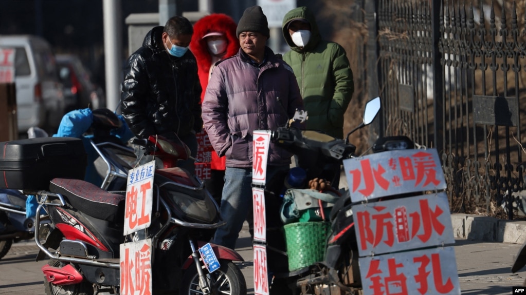 中国辽宁省沈阳市的一条街道上等着“趴活儿”的农民工。(2023年2月6日)(photo:VOA)