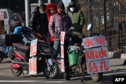 中国辽宁省沈阳市的一条街道上农民工等着“趴活儿”。(2023年2月6日)
