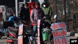 中國遼寧省瀋陽市的一條街道上等著“趴活兒”的農民工。 (2023年2月6日)