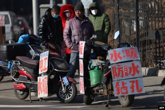 中国辽宁省沈阳市的一条街道上农民工等着“趴活儿”。(2023年2月6日)