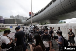 FILE - Journalists wait at a media position outside the Hong Kong West Kowloon railway station, in Hong Kong, China, June 30, 2022.