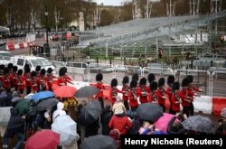 Members of the Coldstream Guards march past seating platforms being erected in preparation of the Coronation of King Charles III, during the Changing of the Guard ceremony outside Buckingham Palace in London, Britain, April 14, 2023.