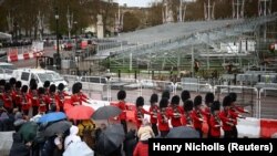 Pasukan Pengawal Kerajaan Inggris berbaris melewati panggung-panggung yang disiapkan untuk upacara Penobatan Raja Charles III, di luar Istana Buckingham, Inggris, Jumat, 14 April 2023. (Foto: Henry Nicholls/Reuters)
