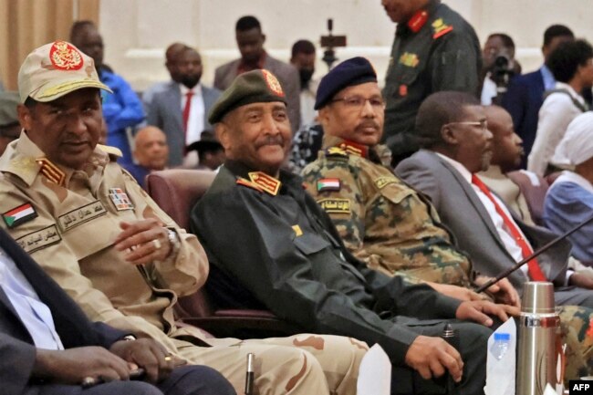 FILE - In this file photo taken on December 05, 2022 Sudan's Army chief Abdel Fattah al-Burhan (2nd-L) and paramilitary commander Mohamed Hamdan Daglo (L) attend the signing ceremony of an initial deal with civilian leaders aimed at ending a deep crisis caused by last year's military coup, in Khartoum. (Photo by ASHRAF SHAZLY / AFP)