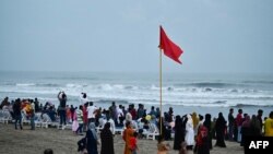 People gather at beach in Cox's Bazar on May 12, 2023, ahead of the landfall of cyclone Mocha. Myanmar and Bangladesh deployed thousands of volunteers and ordered evacuations as the Bay of Bengal's first cyclone of the year approached.