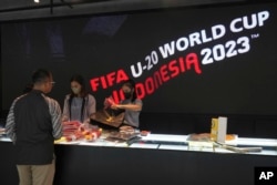 Petugas melayani pelanggan yang berbelanja merchandise resmi FIFA U-20 World Cup di sebuah pusat perbelanjaan di Jakarta, Jumat, 31 Maret 2023. (AP/Tatan Syuflana)