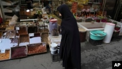 A woman walks through a market in Tehran, Iran, March 15, 2023. Iran's bazaars are packed ahead of the Persian New Year next week, but pocketbooks are severely stretched, and Iranians have little expectation of improvement.
