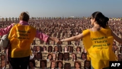 Members of the Baha'i religion demonstrate in Rio de Janeiro's Copacabana beach on June 19, 2011, asking Iranian authorities to release seven Baha'i prisoners accused of spying for Israel and sentenced to 20 years in jail.