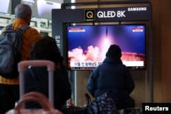 人们在韩国首尔的一处火车站观看朝鲜发射弹道导弹的电视新闻报道。(2023年3月16日)