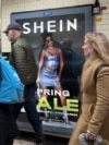 FILE - People walk past an advertisement for Shein, March 8, 2024 in London.