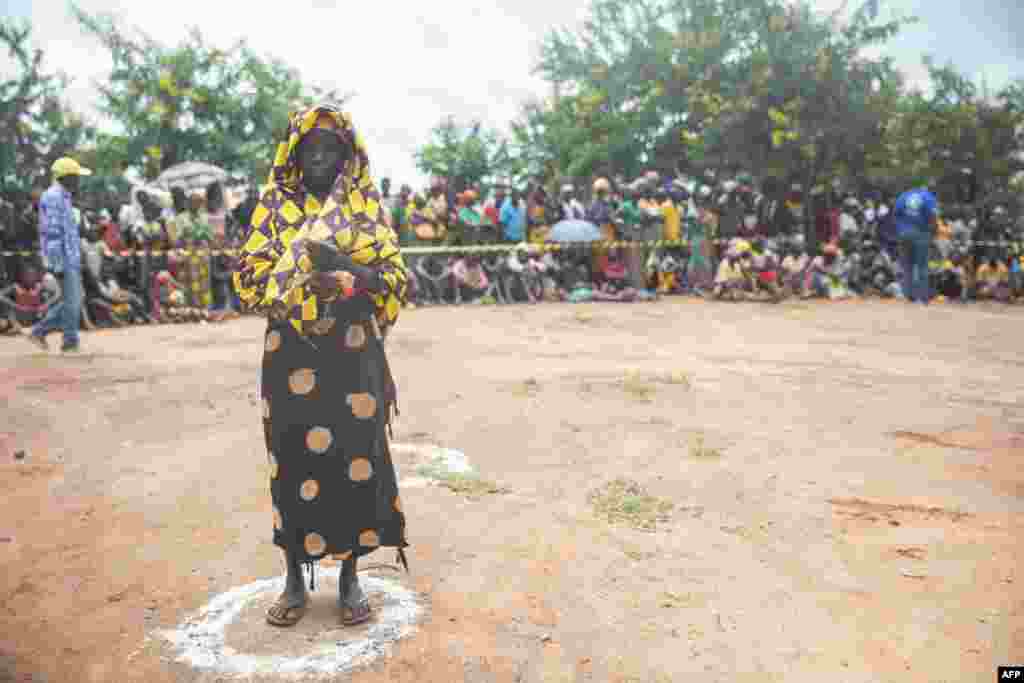 Uma mulher deslocada da província de Cabo Delgado faz fila para receber ajuda humanitária na Escola Tribuna 21 de abril, em Namapa, distrito de Erati, província de Nampula, Moçambique, a 27 de fevereiro de 2024.