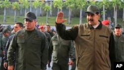 FILE - In this May 2, 2019, photo released by the Miraflores Press Office, Venezuela's President Nicolas Maduro, right, accompanied by Defense Minister Vladimir Padrino, waves upon his arrival to Fort Tiuna, in Caracas, Venezuela.