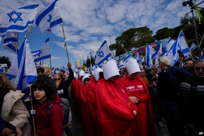 Israelis protest against plans by Prime Minister Benjamin Netanyahu's new government to overhaul the judicial system, outside the Knesset, Israel's parliament, in Jerusalem, Monday, Feb. 13, 2023. (AP Photo/Ohad Zwigenberg)