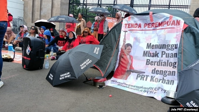 Seratusan orang menggelar aksi tenda perempuan PRT di gerbang DPR RI di Jakarta pada Sabtu (11/3). (Foto: Jala PRT)