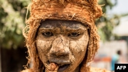 Un homme porte un masque traditionnel de kankurang lors du festival du kankurang à Janjanbureh le 27 janvier 2024. (Photo MUHAMADOU BITTAYE / AFP)