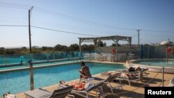 Sejumlah wisatawan tampak bersantai di pinggir kolam renang sebuah hotel di Naxos, Yunani, pada 20 Juni 2024. (Foto: Reuters/Stelios Misinas)