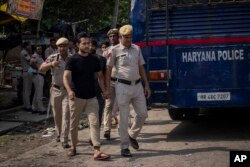 Polisi menahan orang-orang setelah bentrokan komunal di Nuh di negara bagian Haryana, India, Selasa, 1 Agustus 2023. (Foto: AP)