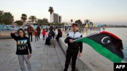 A Libyan boy waves his national flag at the seaside promenade in Benghazi on February 16, 2023.