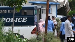 FILE - Police officers take arrested female workers of the Pakistan Tehreek-e-Insaf (PTI) from the party's headquarters into a police van after a security raid in Islamabad on July 22, 2024.