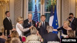 O Presidente francês Emmanuel Macron, a sua mulher Brigitte Macron, o Presidente dos EUA Joe Biden e a primeira-dama Jill Biden brindam durante um jantar de gala no Palácio do Eliseu em Paris, França, a 8 de junho de 2024.