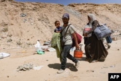 Palestinci nose dete i svoje stvari dok beže iz improvizovanog kampa za raseljene u Kan Junisu u južnom Pojasu Gaze nakon što su izraelski tenkovi zauzeli položaj na brdu iznad tog područja, 18. avgusta 2024.