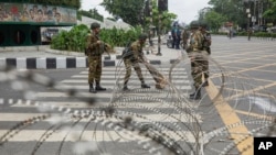 Tentara Bangladesh memasang kawat berduri di jalan utama di Dhaka, Bangladesh, Senin, 22 Juli 2024 pasca bentrokan mematikan dalam aksi protes kuota pekerjaan pemerintah. 