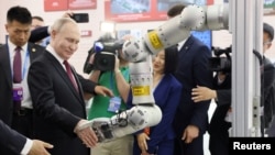 5月17日，俄罗斯总统普京在哈尔滨访问时与机器人握手。