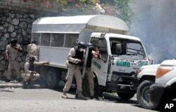 Police take cover from rocks thrown by demonstrators protesting insecurity in Port-au-Prince, Haiti, Aug. 7, 2023.