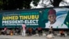 People sit under a billboard with a congratulatory message of the President-Elect Bola Ahmed Tinubu of the All Progressives Congress in Lagos , Nigeria, March 5, 2023.