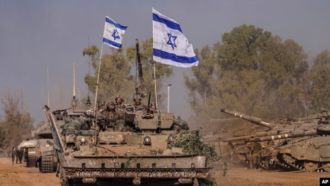Israeli army vehicles arrive to an staging area after combat in the Gaza Strip in southern Israel, Dec. 30, 2023.
