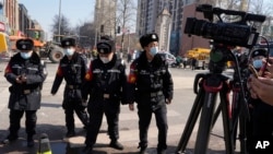 Chinese police officers intervene as journalists report from the scene of an explosion in Sanhe city in northern China's Hebei province on March 13, 2024.