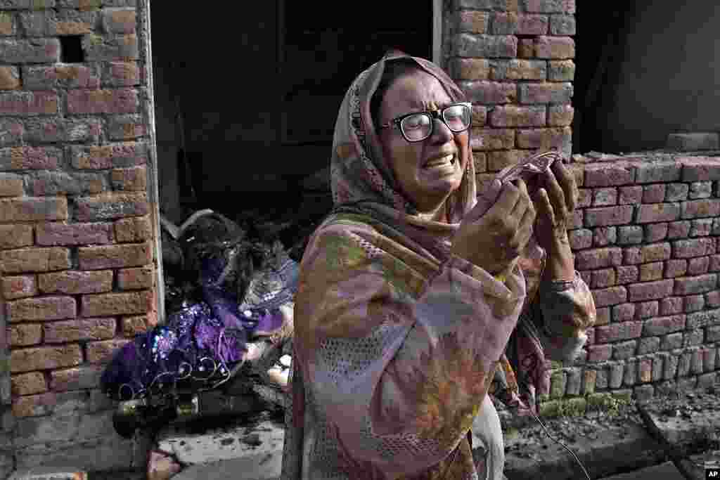 A Christian woman weeps after looking at her home vandalized by an angry Muslim mob in Pakistan on Aug. 17, 2023. 