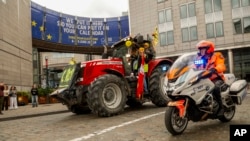 Farmers, escorted by the police, march with tractors during a protest outside the European Parliament in Brussels, Belgium, June 4, 2024.