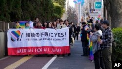 Activists carry a banner in support of same-sex marriage as supporters wave rainbow flags, in Tokyo, Japan, March 14, 2024.