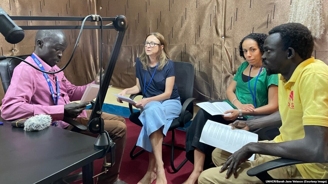 In this undated photo provided by UNHCR, radio journalist Jabrallah Tia interviews members of the UNHCR Forced Displacement survey specialists.