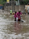 Motorcyclists ride through a flooded street after a heavy rainfall in Lahore, Pakistan, July 1, 2024.