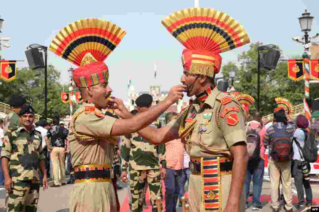 Personil Pasukan Penjaga Perbatasan India saling menawarkan permen pada kesempatan perayaan Hari Kemerdekaan ke-77 negara itu di pos Perbatasan Wagah India-Pakistan, sekitar 35 km dari kota Amritsar.