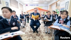 British Foreign Secretary David Cameron meets pupils and takes part in an English lesson at School No.23, during his tour of the Central Asia region, in Ulaanbaatar, Mongolia.