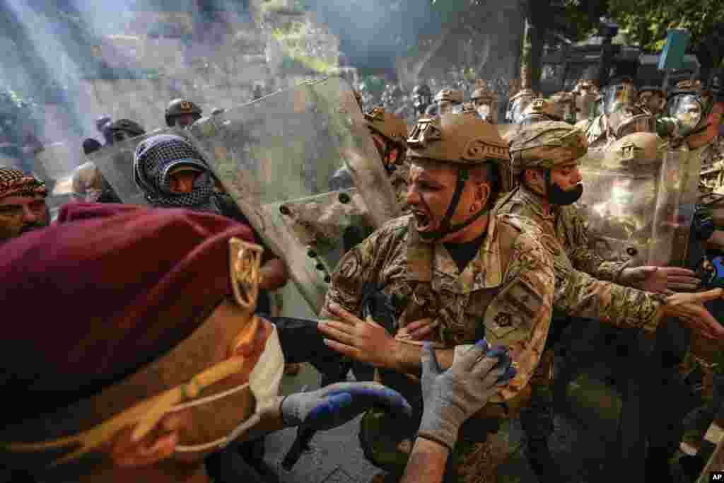 Retired members of the Lebanese security forces and other protesters scuffle with Lebanese army after they removed a barbed-wire barrier in order to advance towards government buildings during a protest in Beirut, April 18, 2023. 