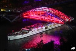 Para atlet berlayar dengan perahu menyusuri Sungai Seine di Paris, Prancis, selama upacara pembukaan Olimpiade Musim Panas 2024, Jumat, 26 Juli 2024. (Foto: AP)