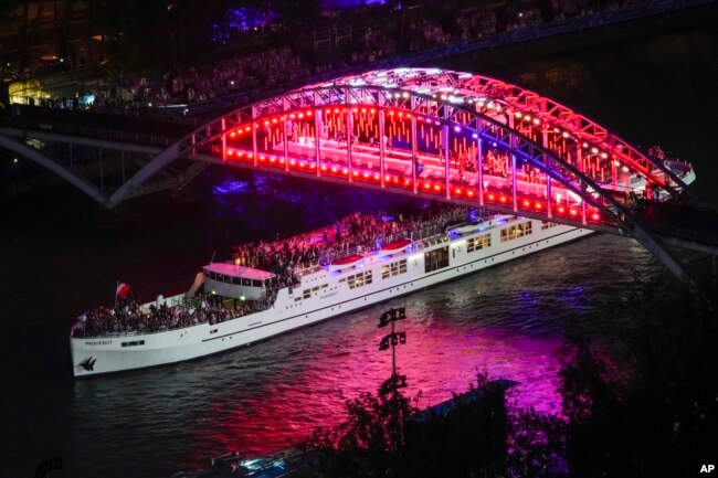 Para atlet berlayar dengan perahu menyusuri Sungai Seine di Paris, Prancis, selama upacara pembukaan Olimpiade Musim Panas 2024, Jumat, 26 Juli 2024. (Foto: AP)