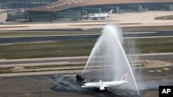 A C919 plane, China's first domestically made passenger jet is welcomed with water jets after completing its maiden commercial flight at the Beijing Capital International Airport in Beijing , May 28, 2023. (Wei Meng/Xinhua via AP)