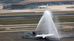 A C919 plane, China's first domestically made passenger jet is welcomed with water jets after completing its maiden commercial flight at the Beijing Capital International Airport in Beijing , May 28, 2023. (Wei Meng/Xinhua via AP)