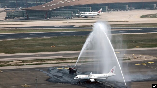 A C919 plane, China's first domestically made passenger jet is welcomed with water jets after completing its maiden commercial flight at the Beijing Capital International Airport in Beijing , May 28, 2023. (Wei Meng/Xinhua via AP)